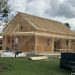 Building under construction, exposed roof beams and plywood covered walls.
